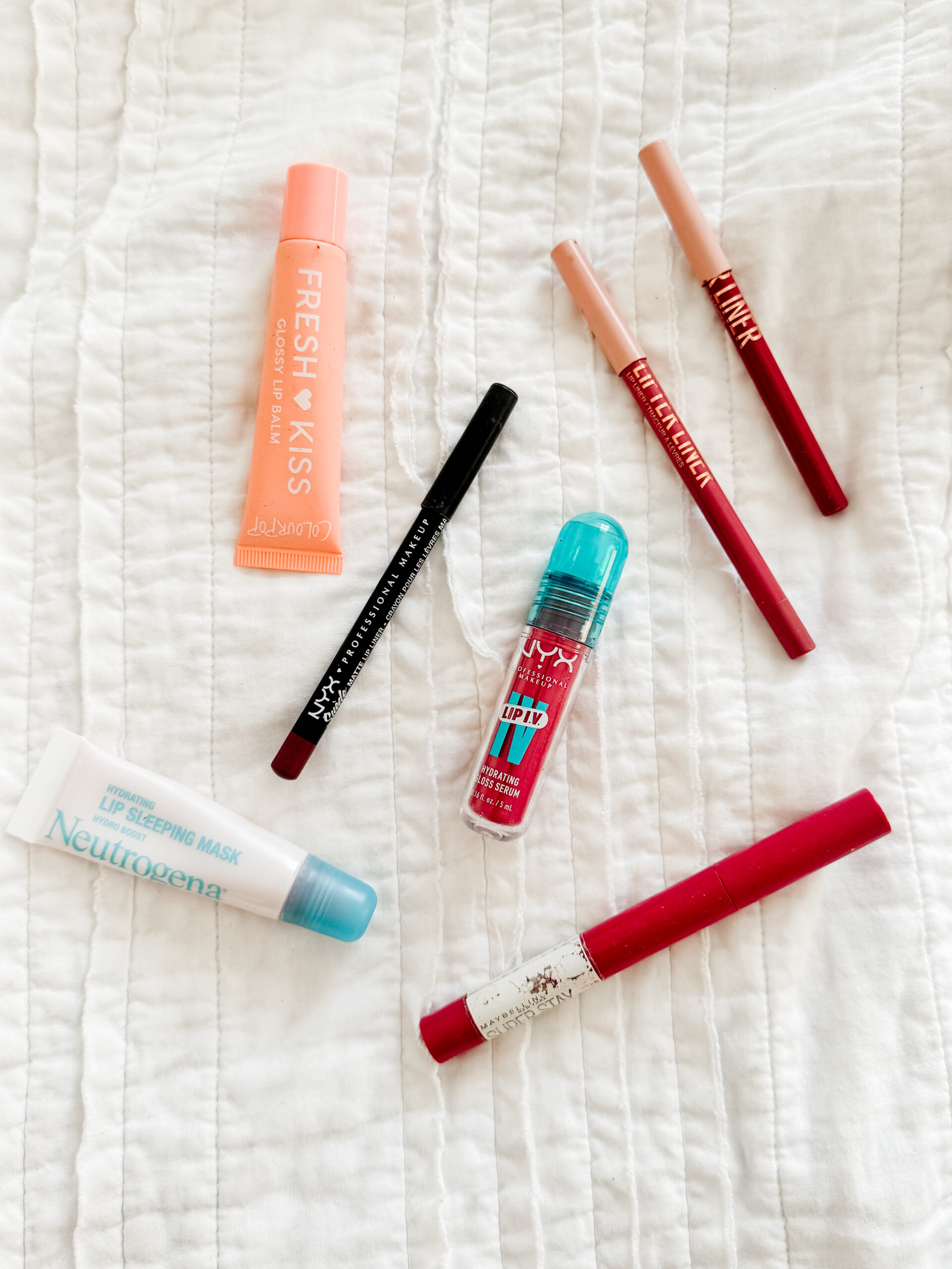 assorted lip products like lip liner, lip gloss, lip stain, lipstick, summer affordable makeup from the drugstore that is hydrating