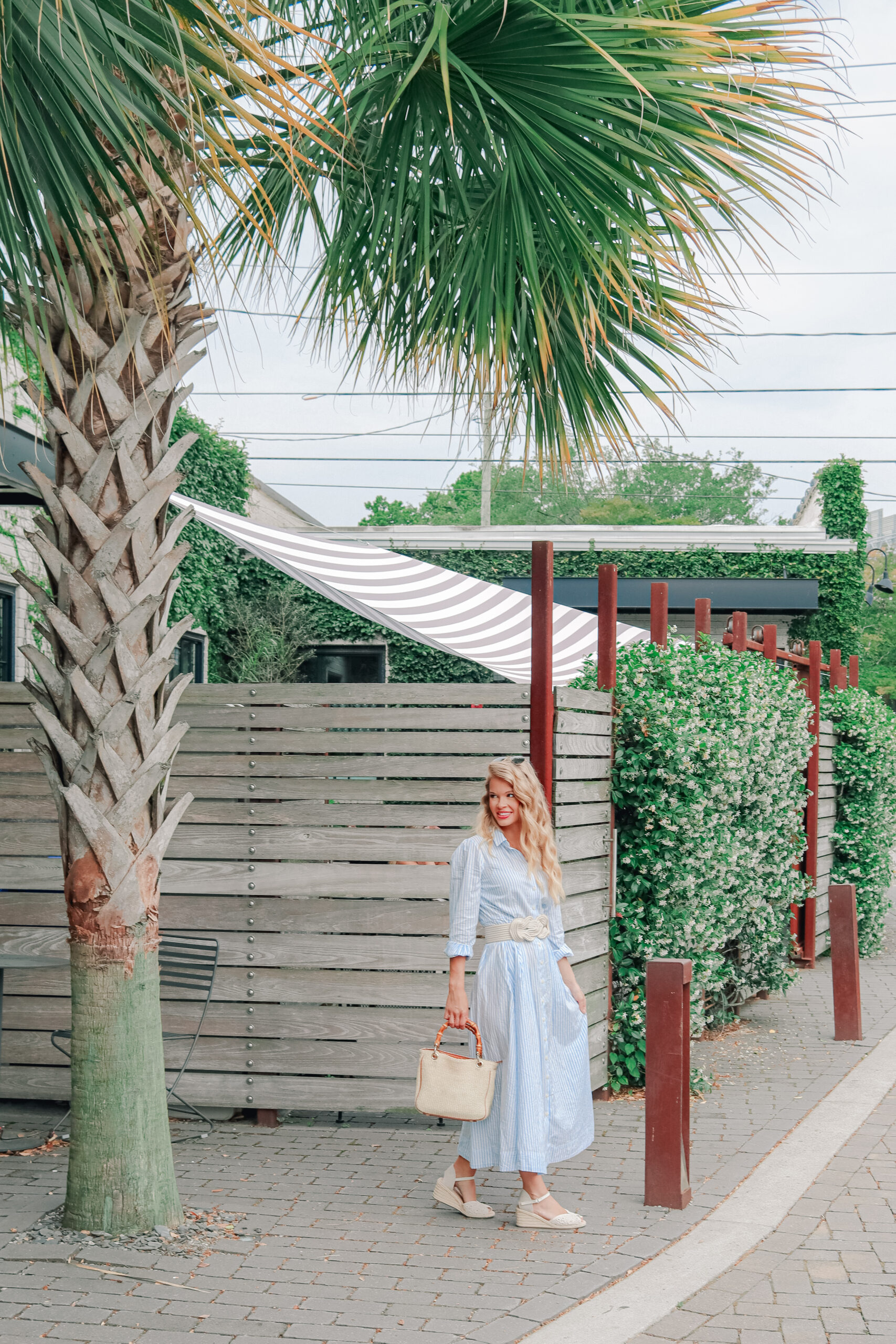 girl wearing blue and white striped dress in downtown charleston, outfit for date night